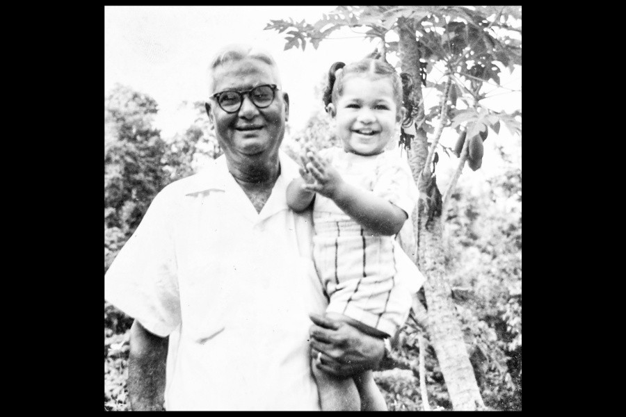 A black and white photo of a man carrying a small girl in his arms