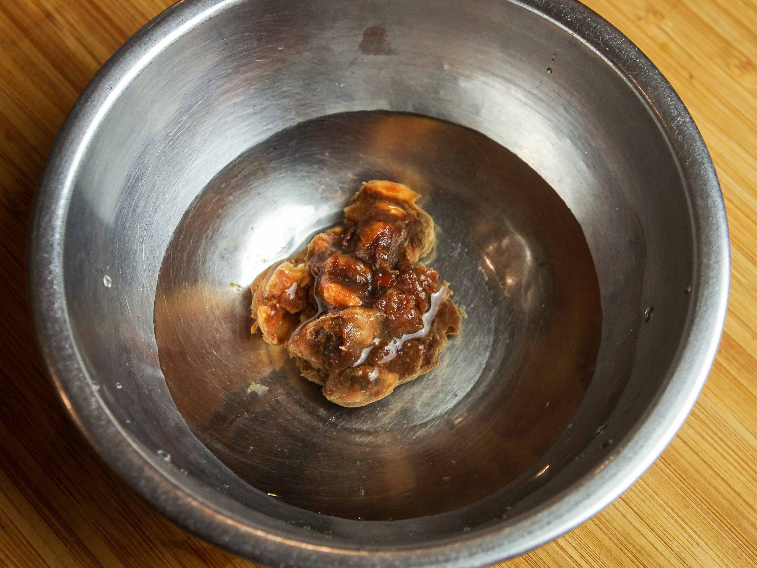 Soaked asam jawa in a metal bowl, on a wooden board,